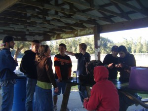 People Okay; Aaron(Mountain Man) is in the jean jacket with his hat on backwards, Lizzy is in the brown and green, Jacob is behind her, Jake is in the blue and orange, Spencer is pointing off into the distance, Josh is looking over Katie's shoulder at something, and John is in the red hoodie.